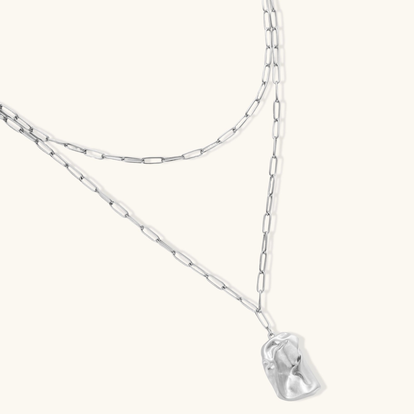 Layered paperclip chain necklace with organic flowing pendant made from eco-zinc alloy in warm gold finish