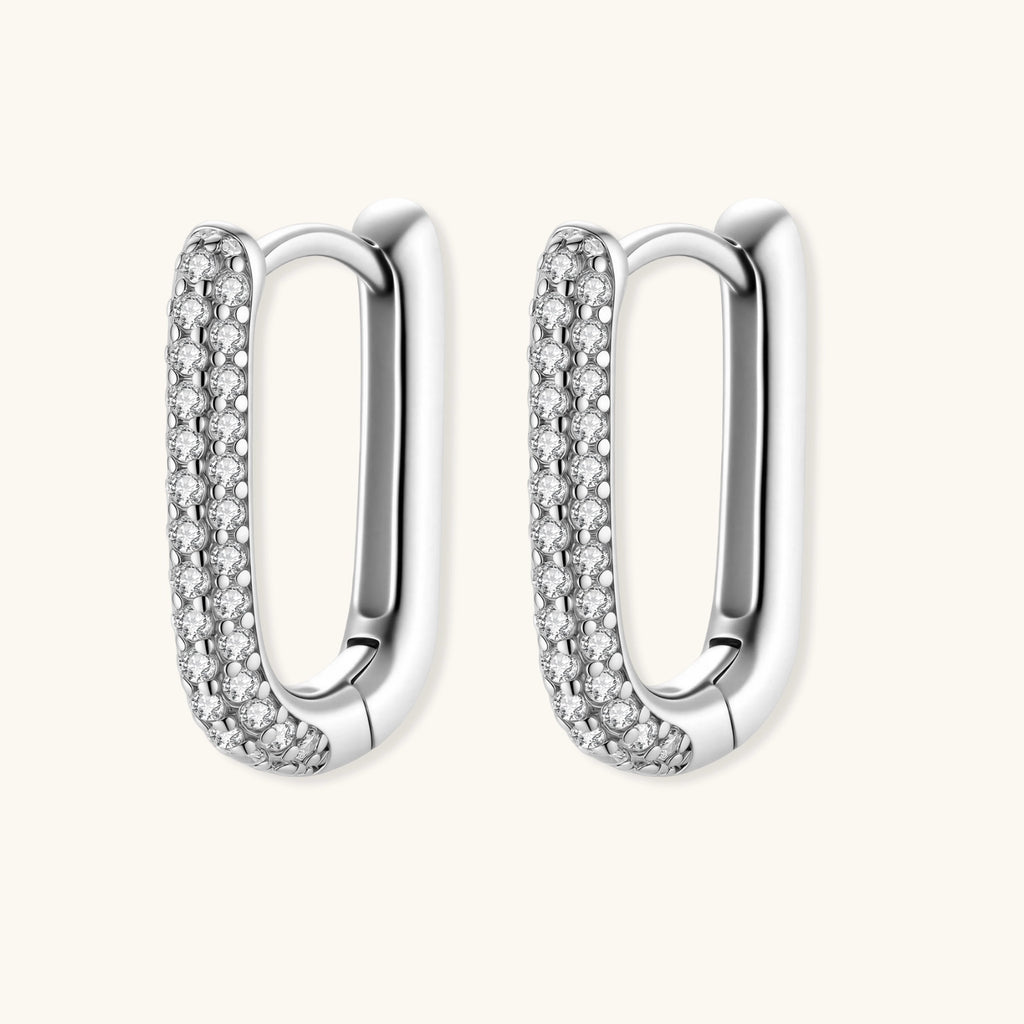 Close-up of small sterling silver huggie hoops completely covered in sparkling clear crystals with hinged closure
