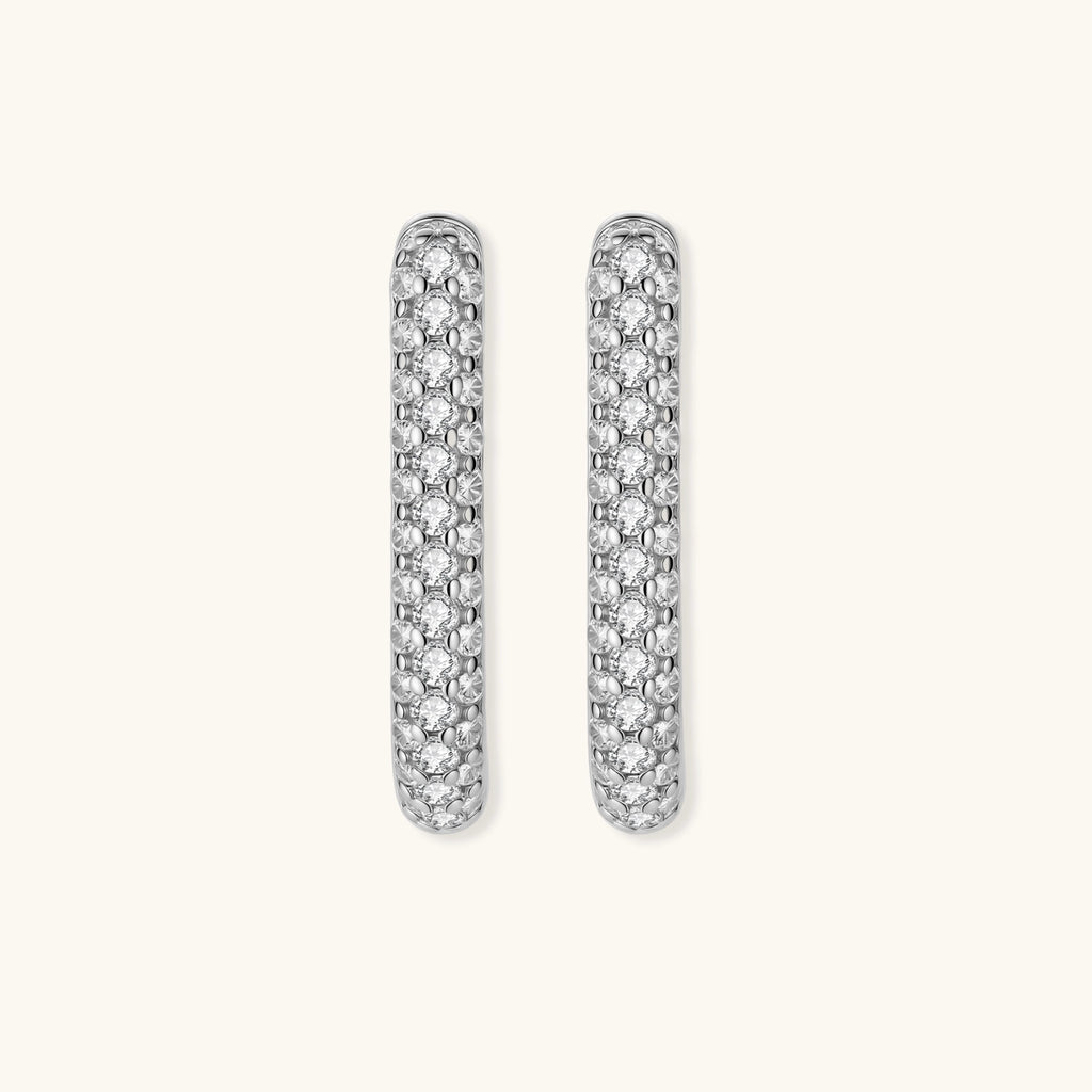 Close-up of small sterling silver huggie hoops completely covered in sparkling clear crystals with hinged closure