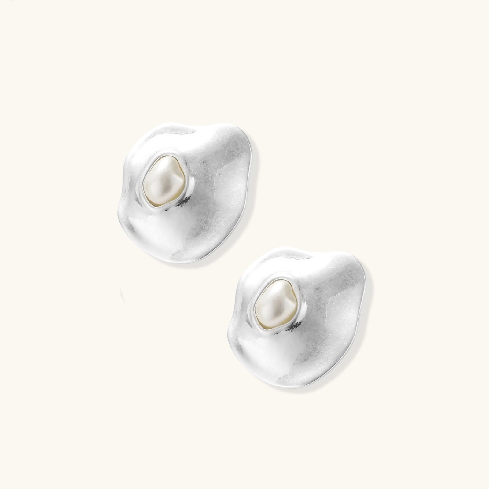 Organic curved earrings and necklace featuring baroque pearls in eco-zinc alloy settings on neutral background